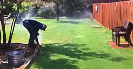 A Lakewood CO Irrigation repair specialist adjusts a pop up sprinkler head